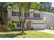 Two-story home with tan siding, black shutters, well-kept lawn, and mature trees at 12320 Tetons Ct, Durham, NC 27703