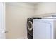 Efficient laundry room with front-load washer and dryer, and wire shelving, ideal for easy organization at 12320 Tetons Ct, Durham, NC 27703