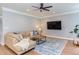 Cozy living room with a ceiling fan, television, and comfortable sectional sofa at 12320 Tetons Ct, Durham, NC 27703
