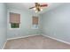 This carpeted bedroom has neutral paint, two windows, a ceiling fan, and a clean and serene atmosphere at 1302 Springlawn Ct, Raleigh, NC 27609
