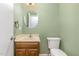Cozy half-bathroom featuring a single sink vanity with a round mirror and toilet at 1302 Springlawn Ct, Raleigh, NC 27609