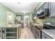 Well-lit kitchen with granite countertops, stainless steel appliances, and tile flooring at 1302 Springlawn Ct, Raleigh, NC 27609