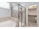 Bright bathroom with a glass enclosed shower, soaking tub, and a walk-in closet at 1304 Rodessa Run, Raleigh, NC 27607