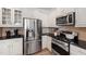Close up of the kitchen featuring stainless steel appliances, black countertops, and white cabinets at 1304 Rodessa Run, Raleigh, NC 27607