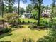 Expansive, well-manicured backyard with lush lawn, mature trees, and fenced perimeter at 1304 Sandpiper Ct, Raleigh, NC 27615