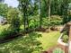Backyard featuring a well-maintained lawn, mature trees, landscaping, and a wooden deck at 1304 Sandpiper Ct, Raleigh, NC 27615
