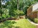 Grassy backyard with a wooden deck, mature trees, and walkway at 1304 Sandpiper Ct, Raleigh, NC 27615