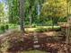 Landscaped backyard with stepping stones through the mulch to the deck at 1304 Sandpiper Ct, Raleigh, NC 27615