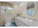 Bright bathroom with double sinks, granite countertops, and a large window for natural light at 1304 Sandpiper Ct, Raleigh, NC 27615
