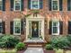 Close-up of the front entrance with decorative wreath, sidelights, and manicured bushes at 1304 Sandpiper Ct, Raleigh, NC 27615