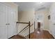 Hallway with hardwood floors, neutral walls, white trim, and access to bedrooms at 1304 Sandpiper Ct, Raleigh, NC 27615