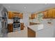Well-lit kitchen featuring wooden cabinets, stainless steel appliances, and white countertops at 1304 Sandpiper Ct, Raleigh, NC 27615
