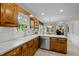 Functional kitchen with stainless steel dishwasher and sink, wood cabinets, and natural light at 1304 Sandpiper Ct, Raleigh, NC 27615