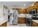 Modern kitchen with stainless steel refrigerator and microwave, wooden cabinets, and sleek countertops at 1304 Sandpiper Ct, Raleigh, NC 27615