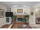 Cozy living room with brick fireplace, built-in shelving, and modern entertainment center at 1304 Sandpiper Ct, Raleigh, NC 27615