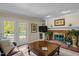 Comfortable living room with a brick fireplace, bright light, and French door access at 1304 Sandpiper Ct, Raleigh, NC 27615