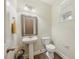 Half bath with a pedestal sink, decorative mirror, and tiled flooring at 132 Ryder Cup Cir, Raleigh, NC 27603