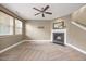 Cozy living room features a fireplace, ceiling fan, and large windows for natural light at 132 Ryder Cup Cir, Raleigh, NC 27603