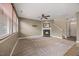 Spacious living room with a cozy fireplace, ceiling fan, and staircase access at 132 Ryder Cup Cir, Raleigh, NC 27603