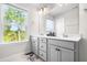 Bright bathroom with dual sinks, shaker cabinets, quartz countertops, and large framed window for natural light at 132 Yellow River Way, Garner, NC 27529