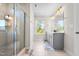 Bright bathroom with tiled floors, a glass shower, updated lighting, gray shaker cabinets, and quartz countertops at 132 Yellow River Way, Garner, NC 27529