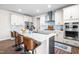 Stylish kitchen features white cabinetry, stainless steel appliances, a breakfast bar, and attractive backsplash at 132 Yellow River Way, Garner, NC 27529