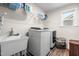 Well-lit laundry room featuring modern washer and dryer, utility sink, and ample shelving at 132 Yellow River Way, Garner, NC 27529