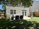 Expansive backyard with a seating area on a concrete patio adjacent to the house and a large grassy lawn at 137 Palmdale Ct, Holly Springs, NC 27540