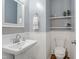 Powder room featuring wainscoting, a stylish mirror, a white sink, and a toilet at 137 Palmdale Ct, Holly Springs, NC 27540