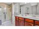 Main bathroom featuring double sinks, a shower, and a well-lit vanity mirror at 137 Palmdale Ct, Holly Springs, NC 27540