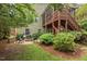Charming backyard with a brick fire pit, surrounded by chairs and lush greenery, with an elevated deck at 1504 Hemlock Hill Dr, Durham, NC 27703