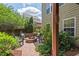 Backyard patio area showcases a brick fire pit and chairs surrounded by lush landscaping at 1504 Hemlock Hill Dr, Durham, NC 27703