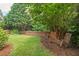 Peaceful backyard features lawn, mature trees, and rocking chairs for relaxation near wooden fence at 1504 Hemlock Hill Dr, Durham, NC 27703