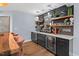 Basement bar area featuring modern fixtures, marble countertops, stylish shelves, and wine and beverage refrigerators at 1504 Hemlock Hill Dr, Durham, NC 27703