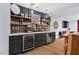 Basement bar area featuring custom cabinetry, marble countertops, a stylish backsplash, and beverage coolers at 1504 Hemlock Hill Dr, Durham, NC 27703