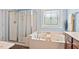 Relaxing bathroom with a jacuzzi tub, separate shower, and decorative window at 1504 Hemlock Hill Dr, Durham, NC 27703