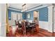 Elegant dining room showcasing hardwood floors, blue accent walls, a modern chandelier, and French doors to the backyard at 1504 Hemlock Hill Dr, Durham, NC 27703