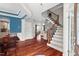 Inviting foyer featuring hardwood floors, staircase, and stylish blue accent wall leading into the kitchen and living area at 1504 Hemlock Hill Dr, Durham, NC 27703