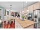 Well-lit kitchen with granite countertops, stainless steel appliances, island, and access to the dining area at 1504 Hemlock Hill Dr, Durham, NC 27703