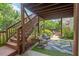Outdoor patio includes stairs to deck, comfortable seating area with a leafy patterned outdoor rug at 1504 Hemlock Hill Dr, Durham, NC 27703