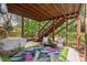 Spacious patio with outdoor seating, a grill, and stairs to the upper deck, nestled in a lush landscape at 1504 Hemlock Hill Dr, Durham, NC 27703