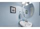 Clean powder room with light blue walls, simple fixtures, and a framed print at 1504 Hemlock Hill Dr, Durham, NC 27703