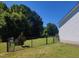 Fenced backyard with lush green grass and mature trees provides privacy for outdoor enjoyment at 160 Inverness St, Zebulon, NC 27597