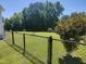 Spacious backyard features a well-maintained lawn, bordered by mature trees and a black chain link fence at 160 Inverness St, Zebulon, NC 27597