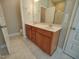 Bathroom featuring a double vanity, wood cabinets, tile floors, and enclosed shower at 160 Inverness St, Zebulon, NC 27597