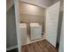 Convenient laundry room with washer, dryer, and storage shelving behind bi-fold doors at 160 Inverness St, Zebulon, NC 27597