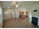 Open-concept living room with vaulted ceiling, fireplace, and hardwood floors leading into the kitchen area at 160 Inverness St, Zebulon, NC 27597
