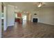 Open-concept living area with wood floors, fireplace, ceiling fan, and seamless flow to kitchen at 160 Inverness St, Zebulon, NC 27597