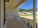 Covered front porch featuring white railing with a view of the neighborhood and green lawn at 160 Inverness St, Zebulon, NC 27597