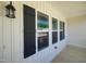 Covered porch featuring white siding, black shutters and trim, and a view of the neighborhood at 160 Inverness St, Zebulon, NC 27597